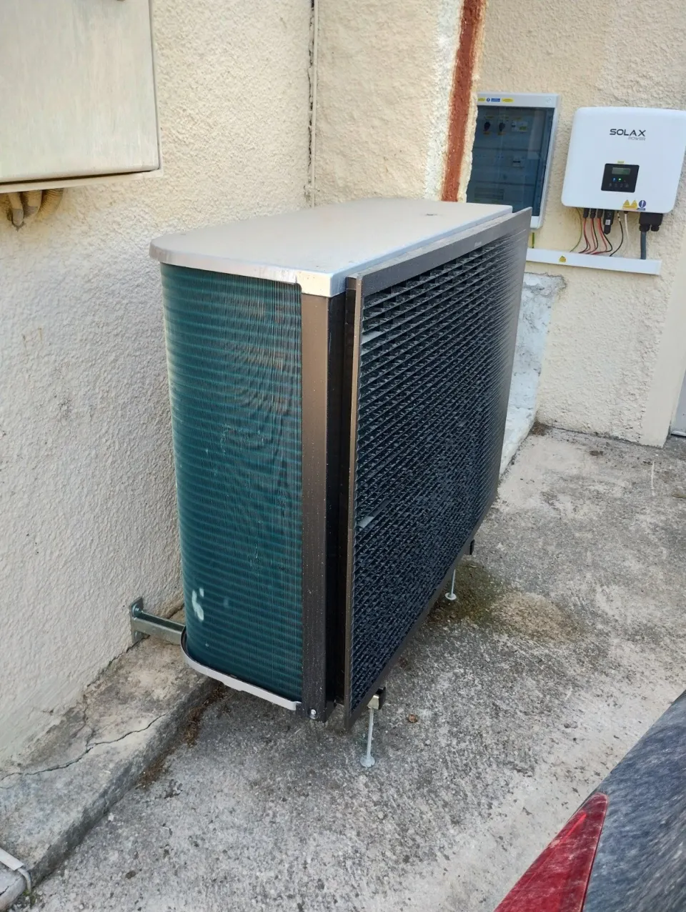 Unité extérieure Daikin posée sur plots au pied d'une façade