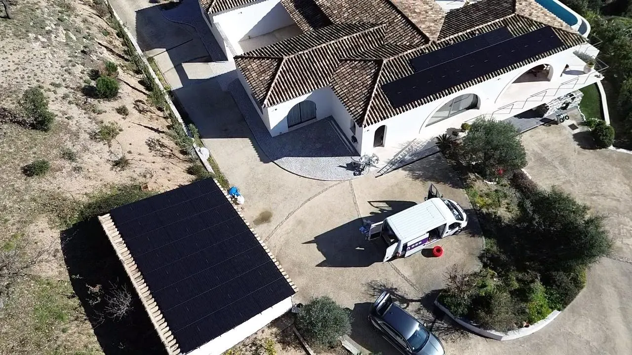 Vue drone du garage entièrement couvert de panneaux et du pan de toiture de la villa